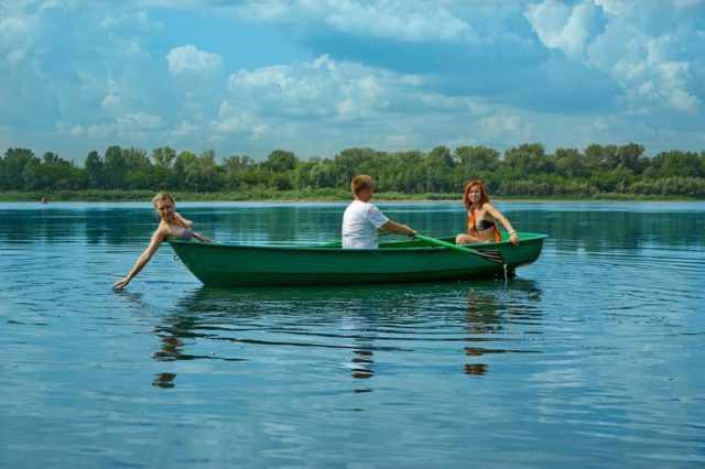 Мужик катает двух женщин на лодке Голавль